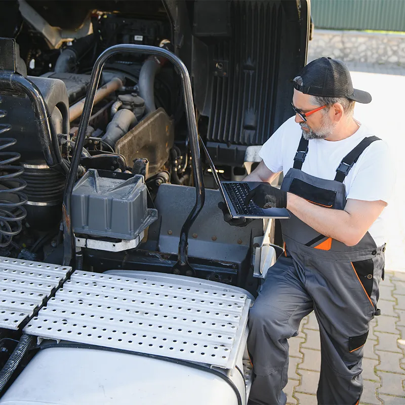 Al Saha technician performing truck ECU programming on a heavy vehicle engine