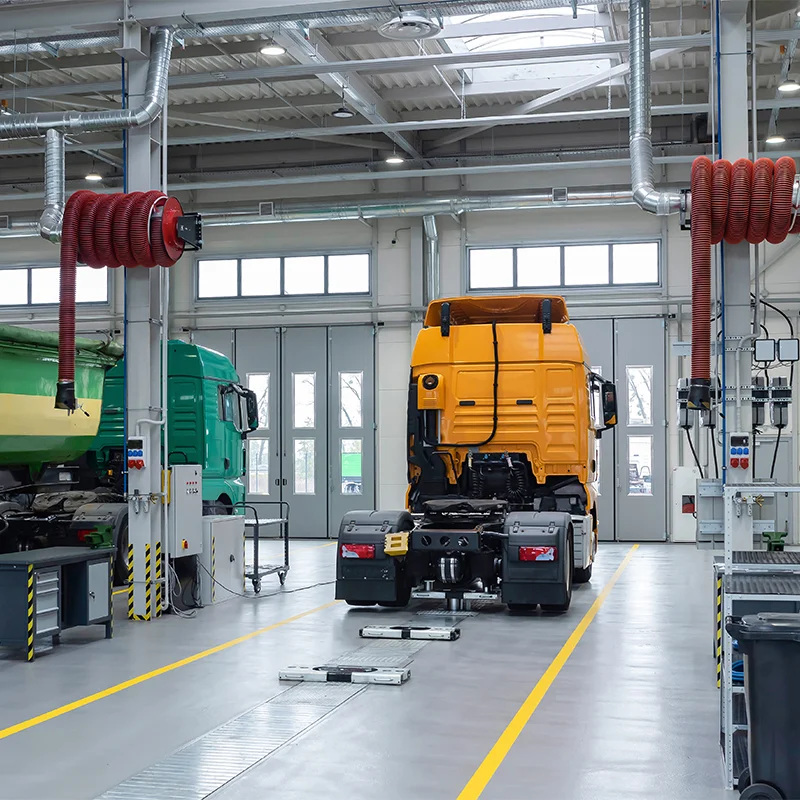 Interior of a professional heavy vehicle workshop with trucks parked inside a large service bay — the type of facility Al Saha operates from in Musaffah, Abu Dhabi