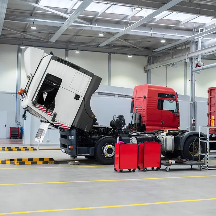 Semi-truck cab tilted for engine inspection inside Al Saha's truck repair shop in UAE